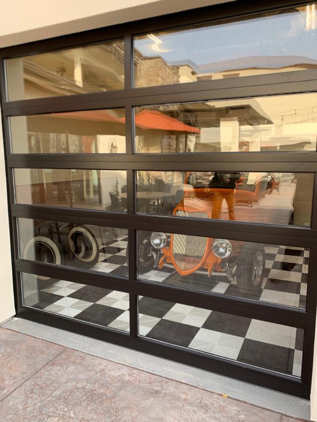 A full view door with an old car behind it.