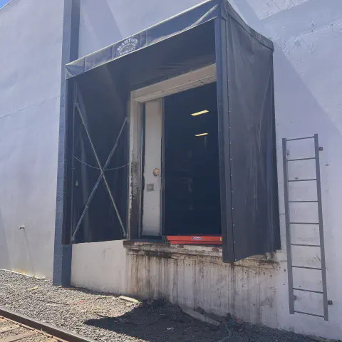 Finished retractable rail dock shelter beside a warehouse rail spur in Modesto